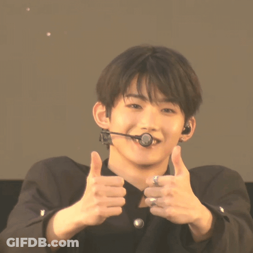 A Young Man Wearing A Microphone Giving A Thumbs Up Sign GIF