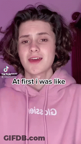 A Young Man Wearing A Pink Hoodie With The Words At First I Was Like Written On It GIF