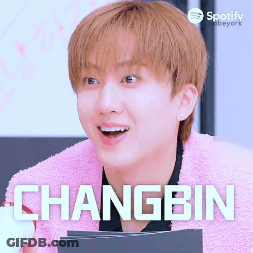A Young Man Wearing A Pink Sweater And The Name Changbin GIF