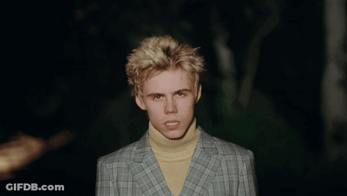 A Young Man Wearing A Plaid Jacket And Yellow Turtleneck GIF