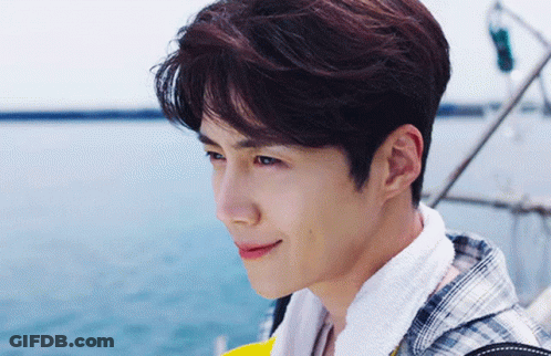 A Young Man Wearing A Plaid Shirt And A Towel Around His Neck GIF