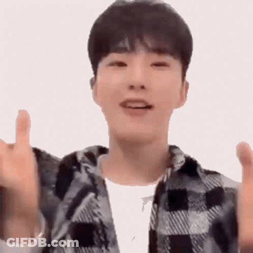 A Young Man Wearing A Plaid Shirt Is Giving A Thumbs Up Sign . GIF