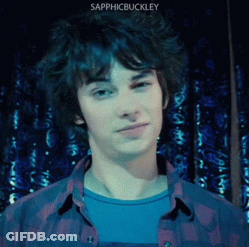 A Young Man Wearing A Plaid Shirt With The Name Sapphicbuckley On The Bottom Right GIF