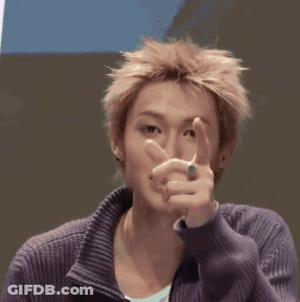 A Young Man Wearing A Purple Sweater Is Touching His Forehead GIF