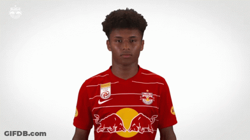 A Young Man Wearing A Red Bull Jersey Is Making A Gesture With His Hands GIF