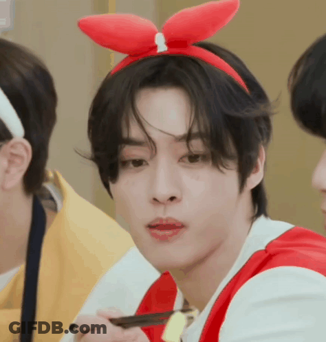 A Young Man Wearing A Red Bunny Ear Headband Is Eating With Chopsticks . GIF