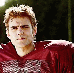 A Young Man Wearing A Red Football Jersey With The Letter M On The Front GIF