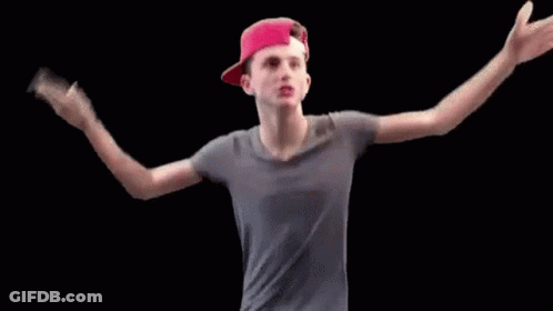 A Young Man Wearing A Red Hat And A Gray Shirt Is Dancing . GIF