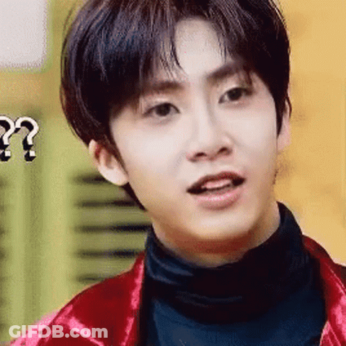 A Young Man Wearing A Red Jacket And Black Turtleneck Is Making A Funny Face . GIF