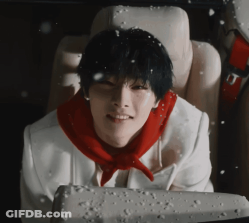 A Young Man Wearing A Red Scarf Is Sitting In A Car Seat GIF