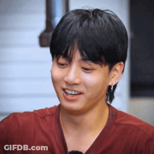 A Young Man Wearing A Red Shirt And Earrings Smiles GIF
