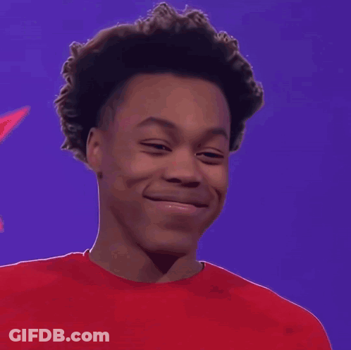 A Young Man Wearing A Red Shirt Is Smiling GIF