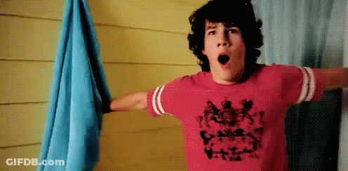 A Young Man Wearing A Red T-Shirt With A Picture Of A Person On It GIF