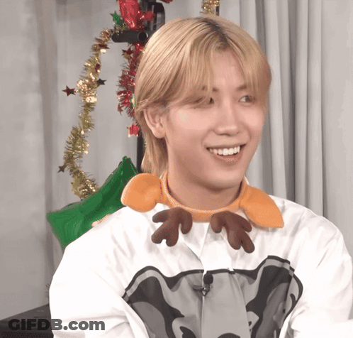 A Young Man Wearing A Reindeer Headband Smiles GIF