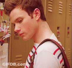 A Young Man Wearing A Striped Shirt And Carrying A Purse GIF