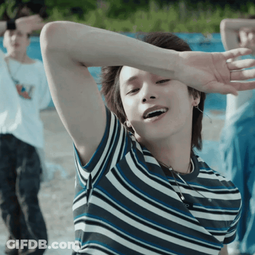 A Young Man Wearing A Striped Shirt Is Smiling GIF