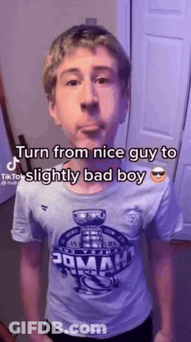 A Young Man Wearing A T-Shirt That Says `` Turn From Nice Guy To Slightly Bad Boy '' GIF