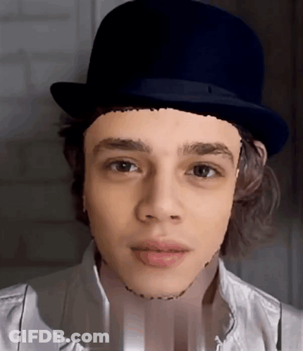 A Young Man Wearing A Top Hat With A Drawing Of His Face On It GIF