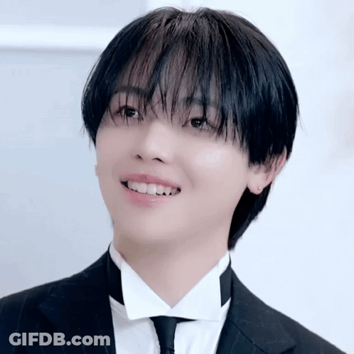 A Young Man Wearing A Tuxedo And Tie Is Smiling GIF