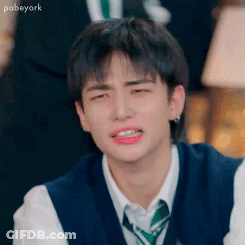 A Young Man Wearing A Vest And Tie Is Crying . GIF