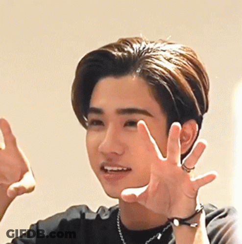 A Young Man Wearing A Watch And A Necklace Is Making A Funny Face GIF