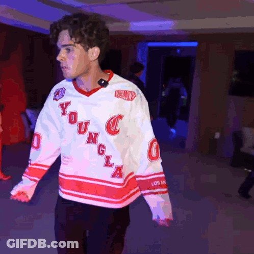 A Young Man Wearing A White And Red Jersey With The Word Young On It GIF