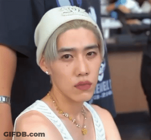 A Young Man Wearing A White Beanie And A White Tank Top . GIF