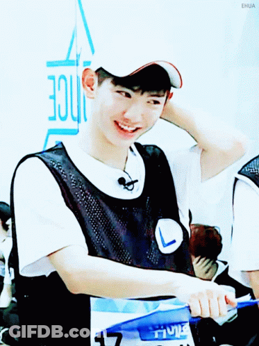 A Young Man Wearing A White Hat And A Black Vest Is Smiling GIF