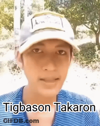 A Young Man Wearing A White Hat And A Blue Shirt Is Talking . GIF