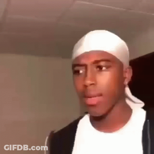 A Young Man Wearing A White Headband And A Black Jacket Is Making A Funny Face . GIF
