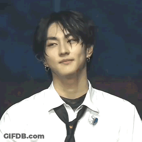 A Young Man Wearing A White Shirt And A Black Tie With A Pin That Says ' S ' On It GIF