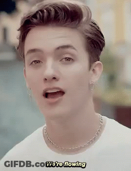 A Young Man Wearing A White Shirt And A Chain Necklace Says We 'Re Flowing GIF