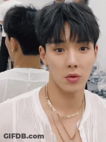 A Young Man Wearing A White Shirt And A Gold Necklace GIF