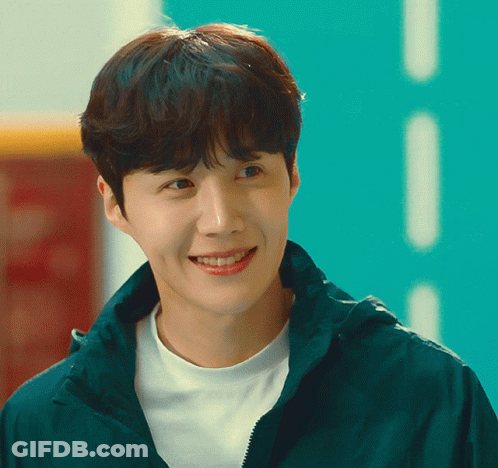A Young Man Wearing A White Shirt And A Green Jacket Smiles For The Camera GIF