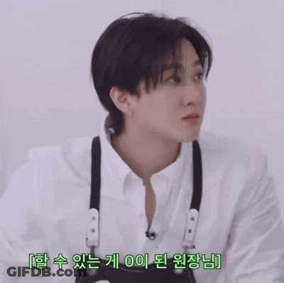 A Young Man Wearing A White Shirt And Black Suspenders Is Looking At Something GIF