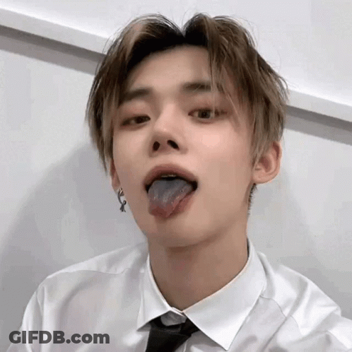 A Young Man Wearing A White Shirt And Tie Is Sticking Out His Tongue . GIF