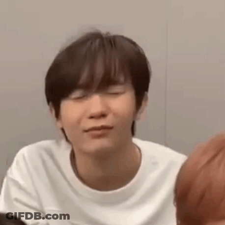 A Young Man Wearing A White T-Shirt Is Making A Funny Face . GIF