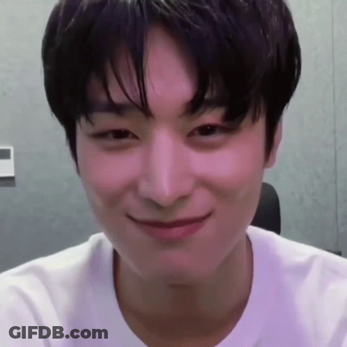 A Young Man Wearing A White T-Shirt Is Smiling GIF
