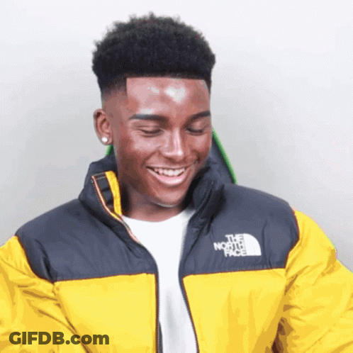 A Young Man Wearing A Yellow North Face Jacket Smiles GIF