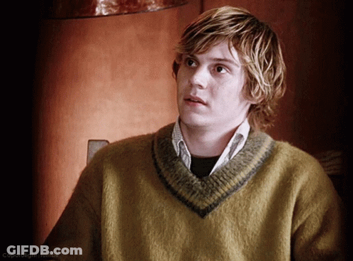 A Young Man Wearing A Yellow Sweater With A Gray Stripe On The Collar GIF
