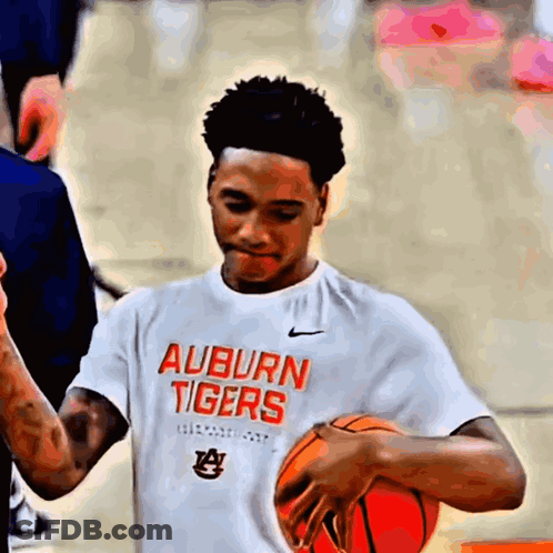 A Young Man Wearing An Auburn Tigers T-Shirt Holds A Basketball GIF