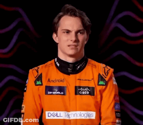 A Young Man Wearing An Orange Racing Suit With Dell Technologies Written On It GIF