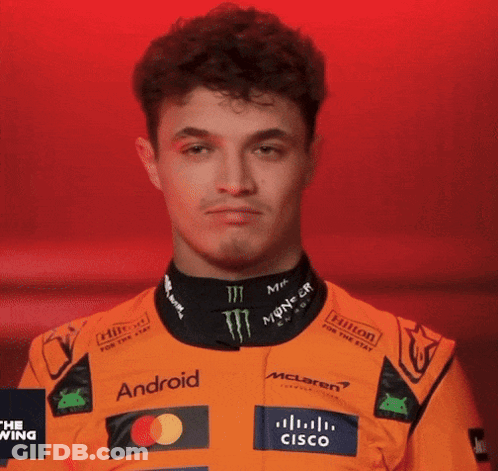 A Young Man Wearing An Orange Racing Suit With Logos For Android And Cisco GIF