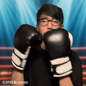 A Young Man Wearing Boxing Gloves And Glasses GIF