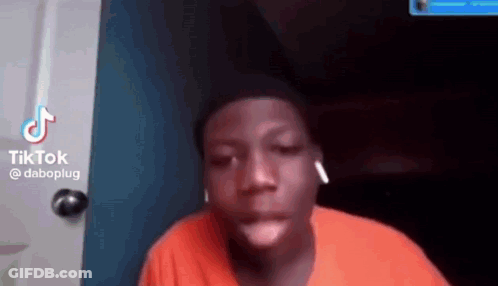 A Young Man Wearing Ear Buds Is Making A Funny Face . GIF