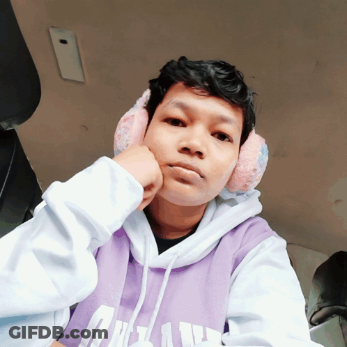 A Young Man Wearing Ear Muffs And A Purple Hoodie With The Letter U On It GIF