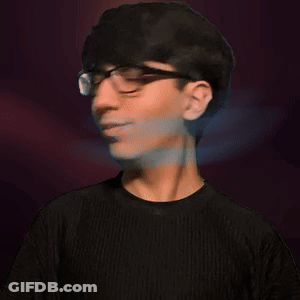 A Young Man Wearing Glasses And A Black Shirt Looks At The Camera GIF
