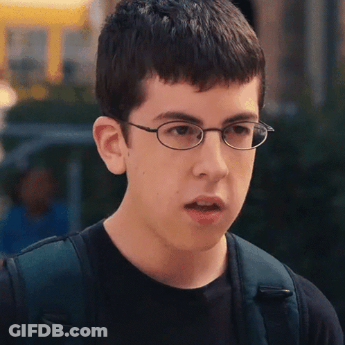 A Young Man Wearing Glasses And A Black Shirt Looks Surprised GIF