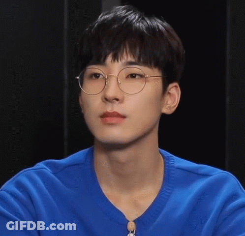 A Young Man Wearing Glasses And A Blue Shirt Looks At The Camera GIF