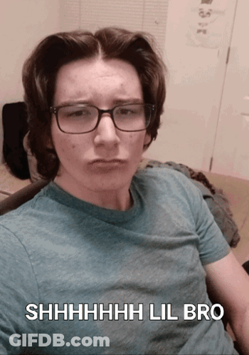 A Young Man Wearing Glasses And A Blue Shirt Says Shhhh Lil Bro On The Bottom GIF